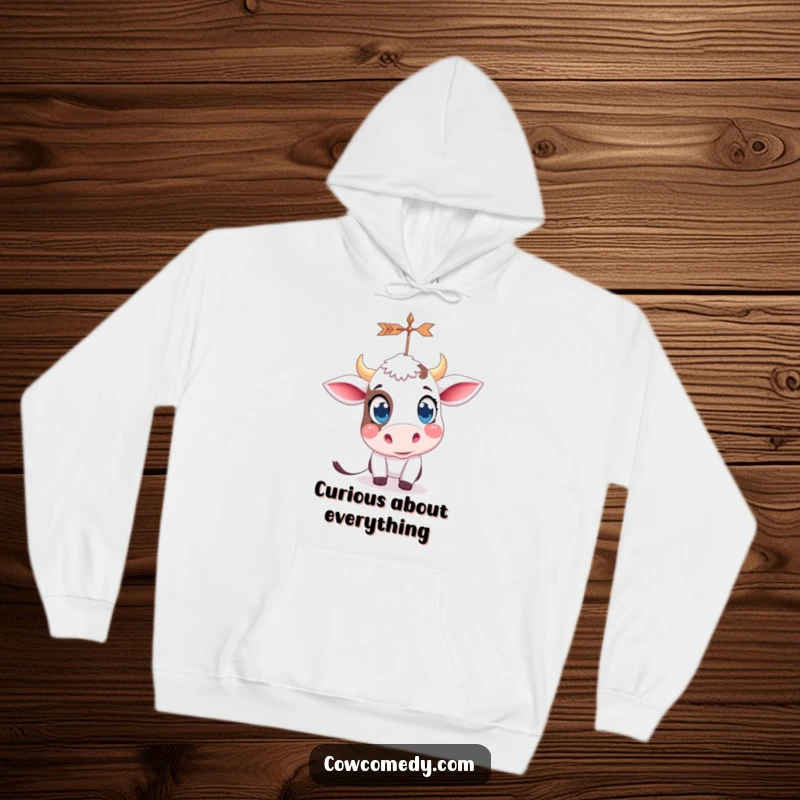Funny kawaii cow with big, curious eyes, looking at a spinning weather vane, depicted on a warm, comfortable hoodie.