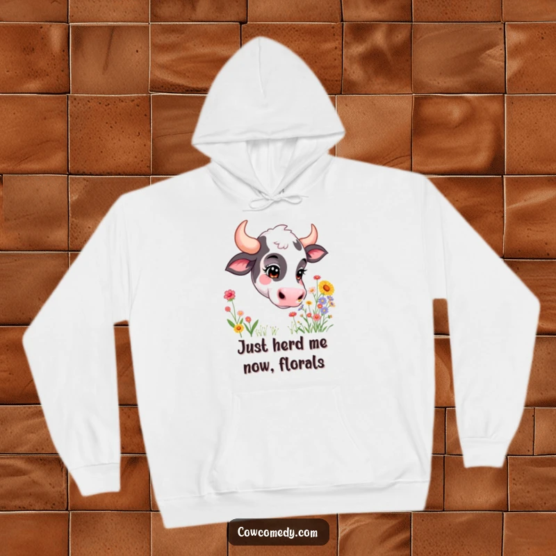 Funny hoodie depicting a curious cow with its eyes closed, deeply inhaling a colorful explosion of wildflowers. Cozy and humorous.