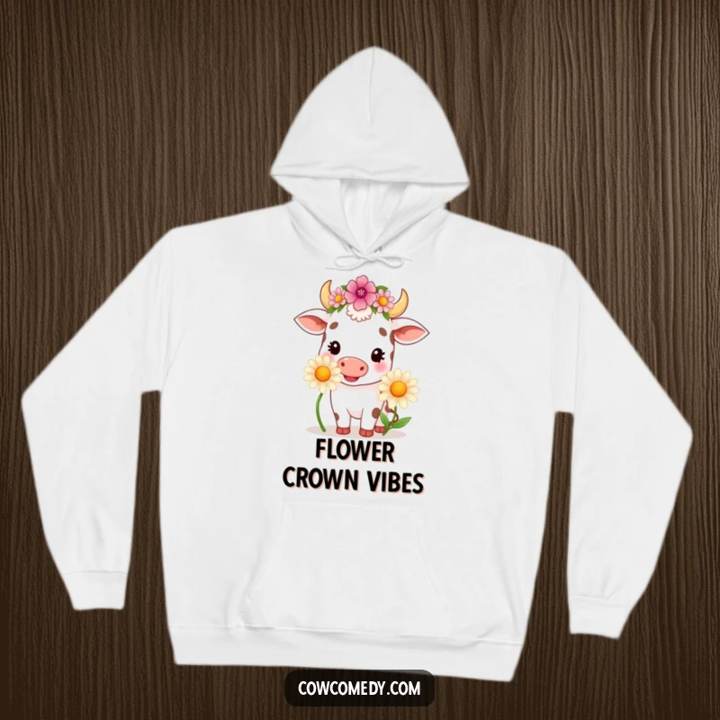 Funny kawaii cow wearing a flower crown, happily chewing a large daisy, depicted on a warm, comfortable hoodie.