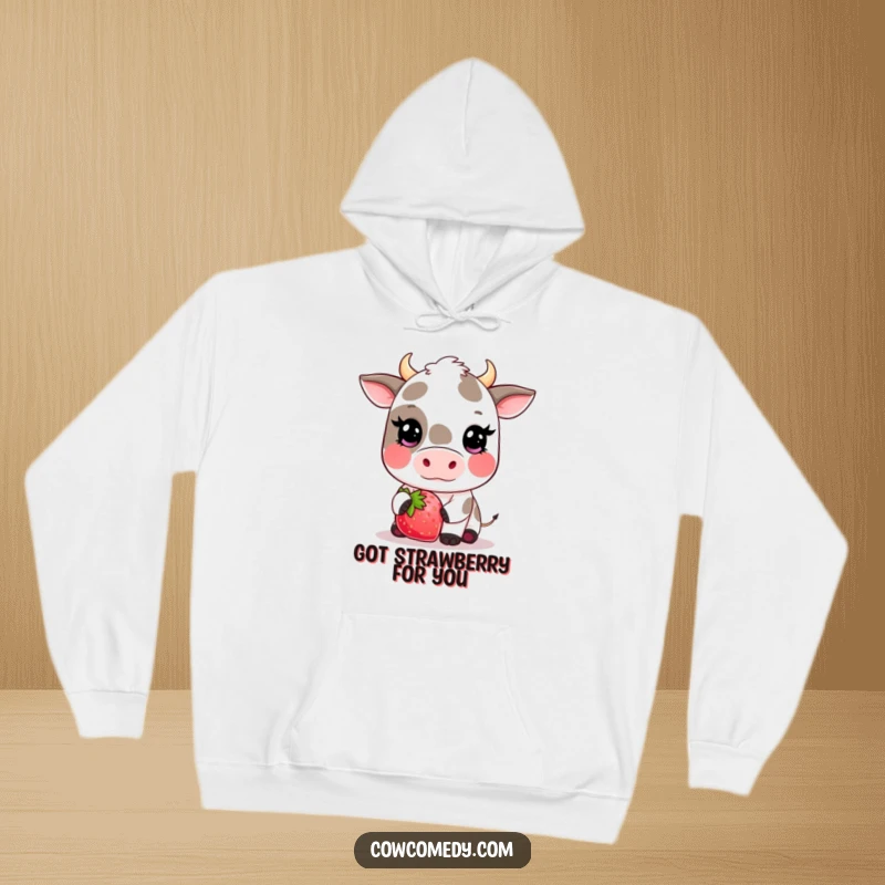 Funny kawaii cow hoodie depicting a shy, blushing cow presenting a huge strawberry, offering cozy comfort and adorable style.