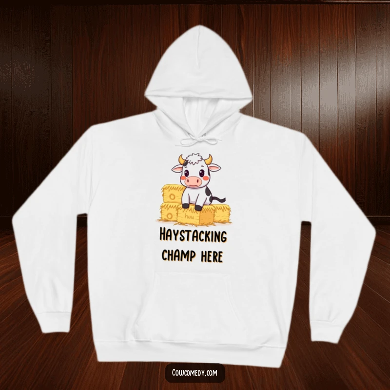 Funny Hoodie depicting a determined cow intensely balancing a large hay stack, exuding strength and humorous motivation.