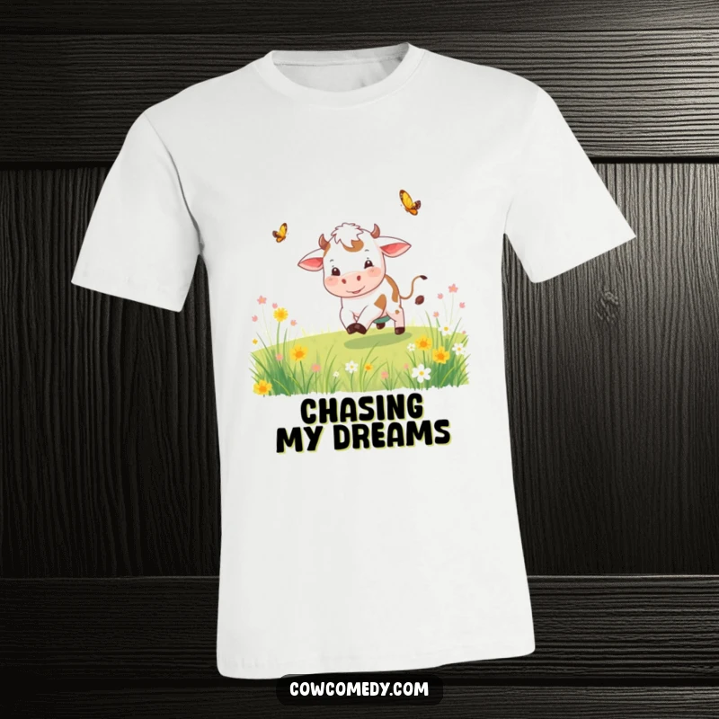 Funny playful cow t-shirt showing a cow joyfully chasing a butterfly through a sunlit meadow, vibrant and cheerful.