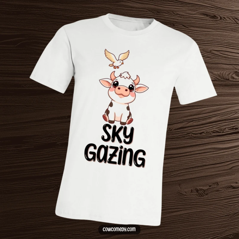Funny t-shirt with a cow's big, friendly eyes looking upwards at a bird in flight. A whimsical and charming graphic tee for animal lovers.