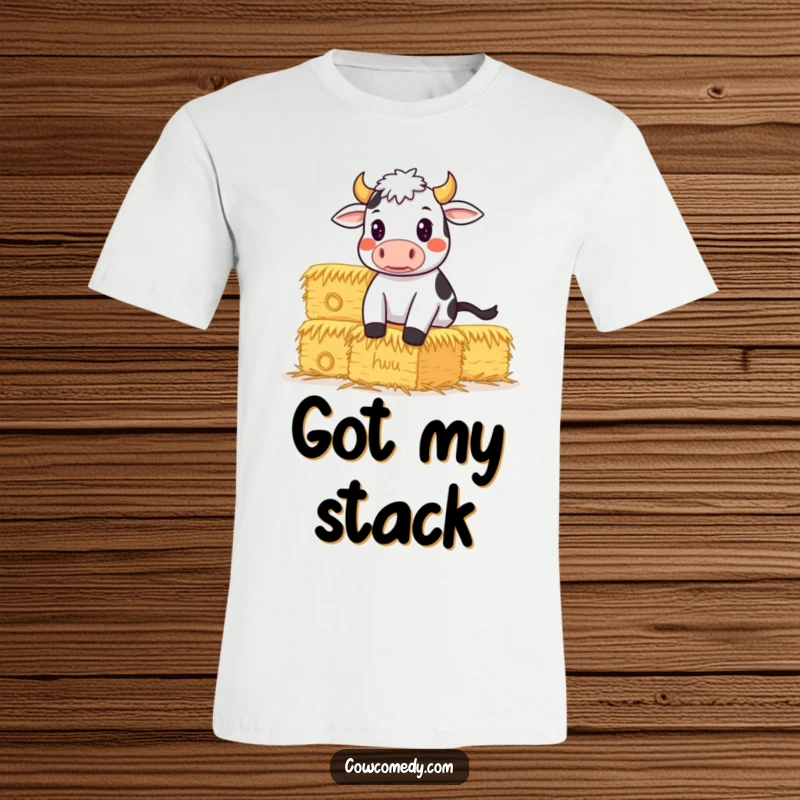 Funny T-Shirt of a determined cow focused on balancing a huge stack of hay bales, symbolizing hard work and humor.